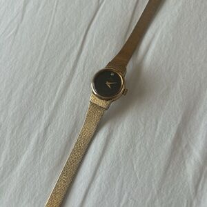Gold analog watch with black watch face